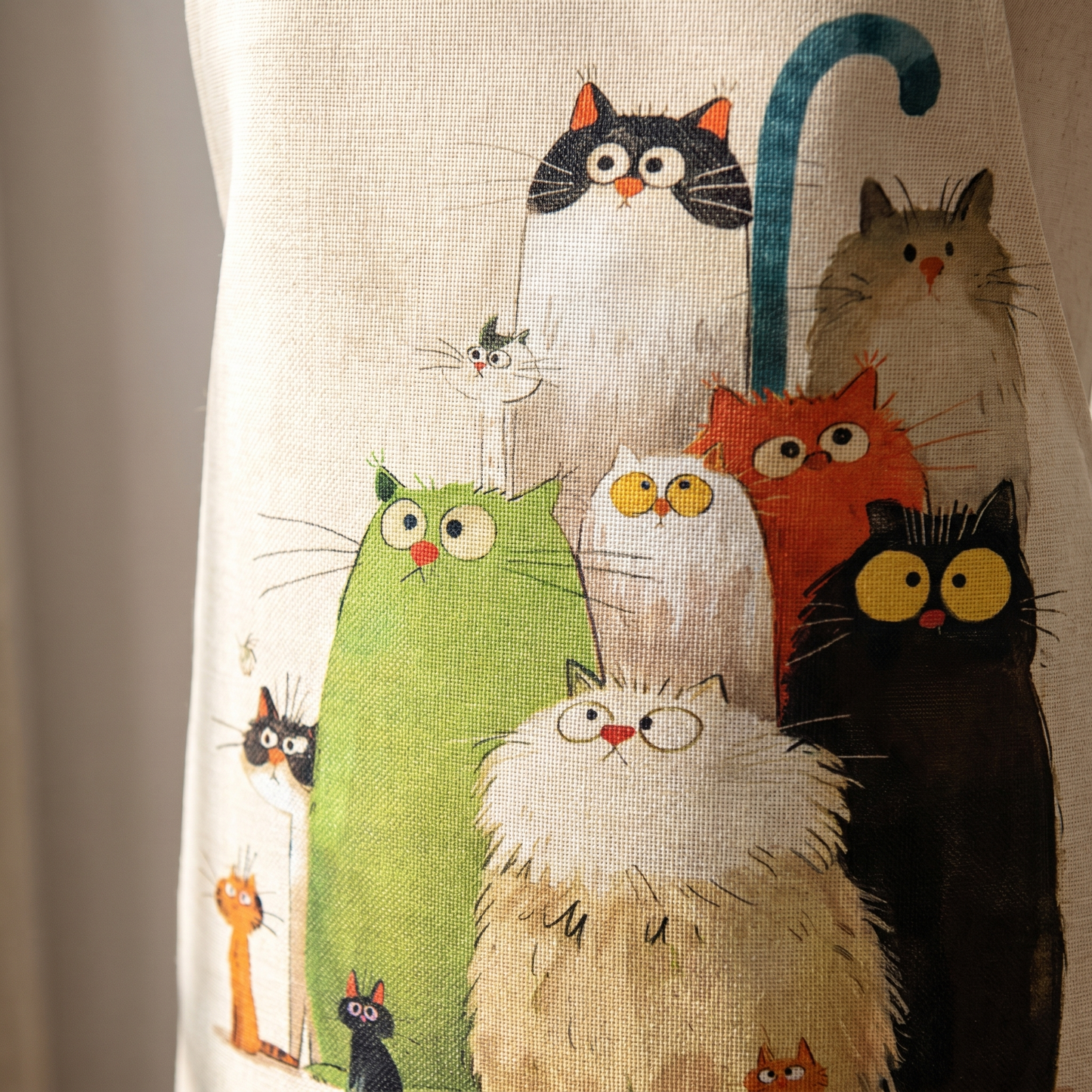 Close-up of the linen weave and the ten cats stitched onto the apron