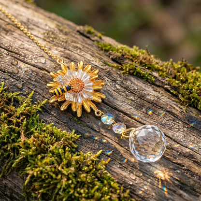 Gold sunflower-and-bee crystal light-catcher on mossy wood with dew