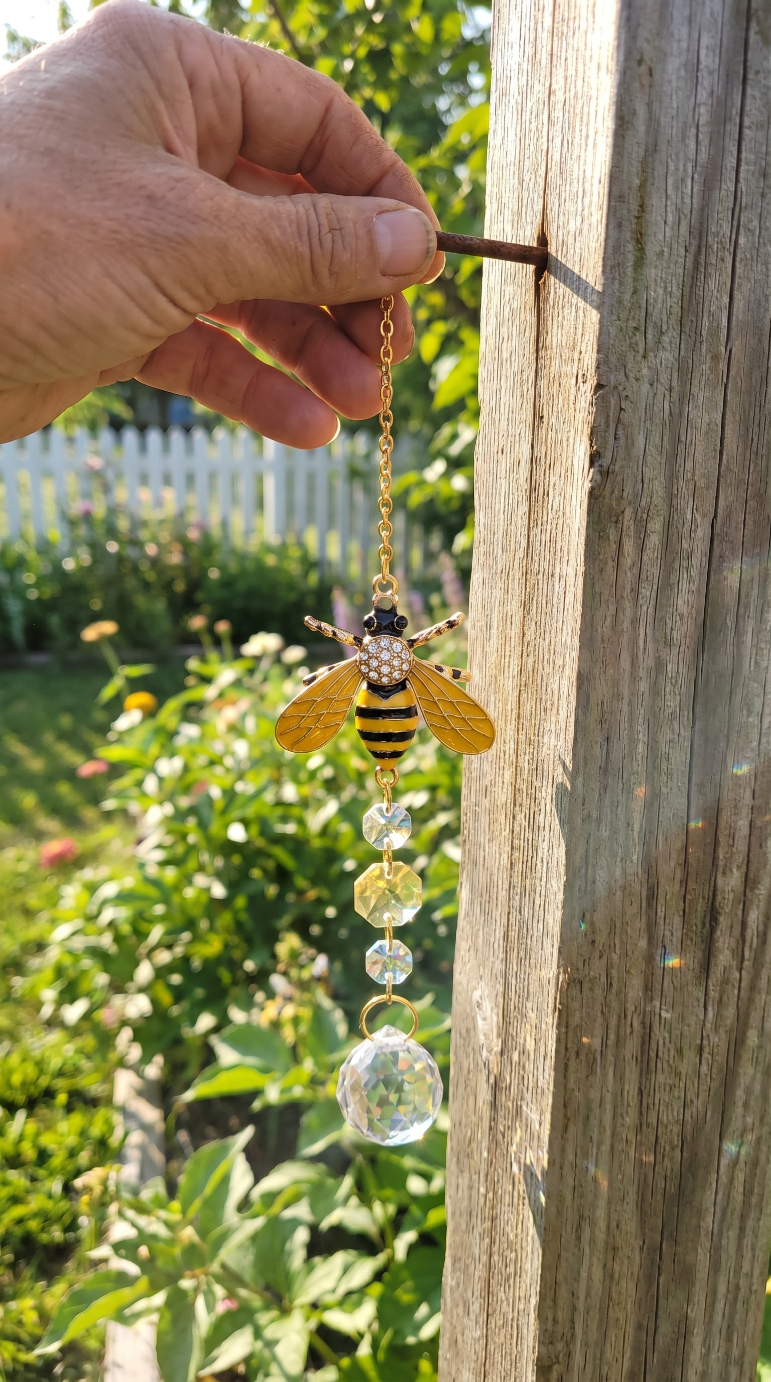 UGC hanging the suncatcher on a fence post