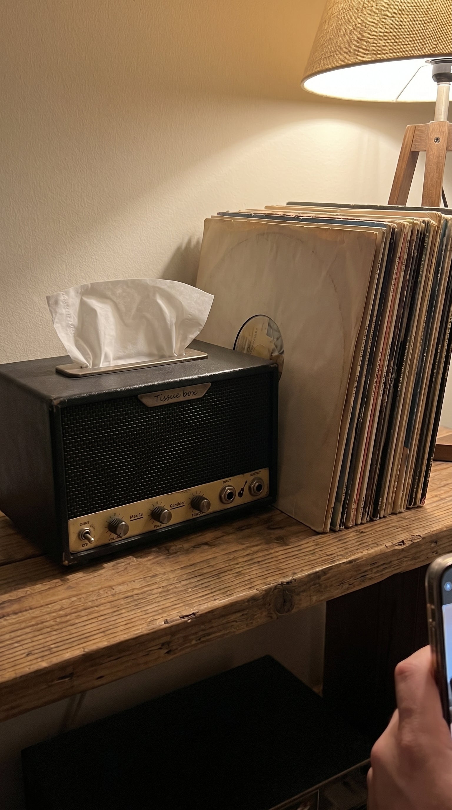 Guitar-amp tissue box on a shelf beside vinyl records