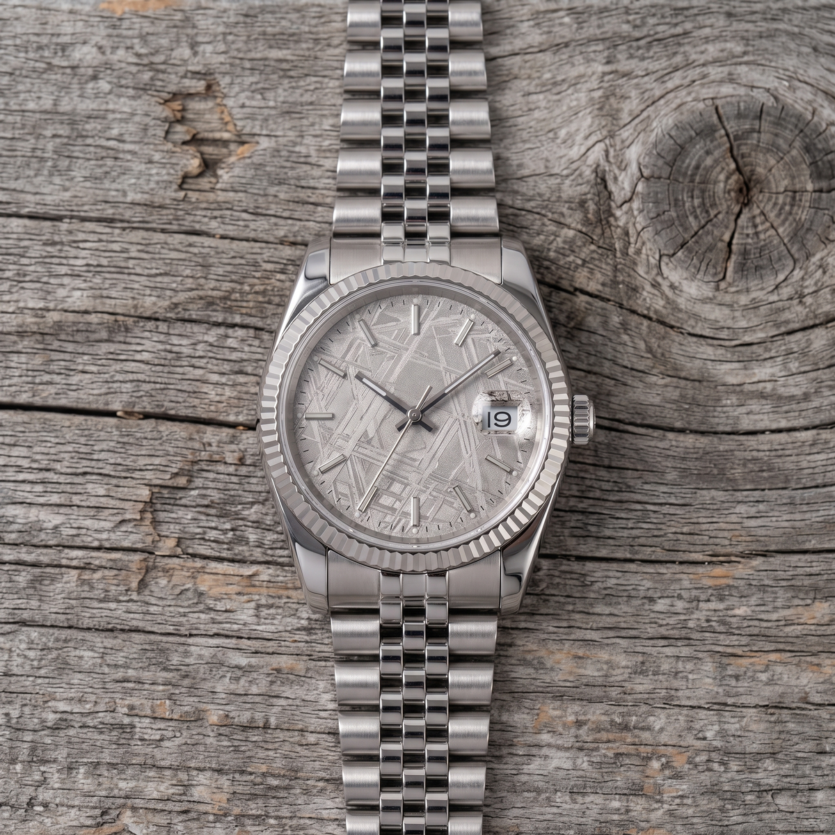 Meteorite dial watch with fluted bezel and jubilee bracelet, seen from above on barn wood