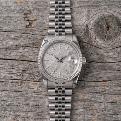 Meteorite dial watch with fluted bezel and jubilee bracelet, seen from above on barn wood