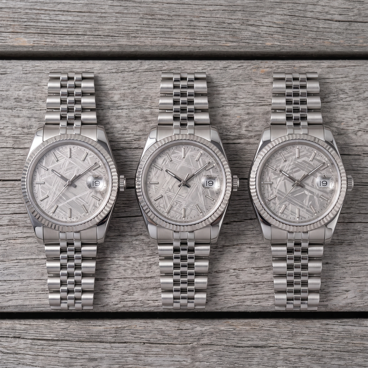 Three watches side by side, each dial a different natural meteorite pattern