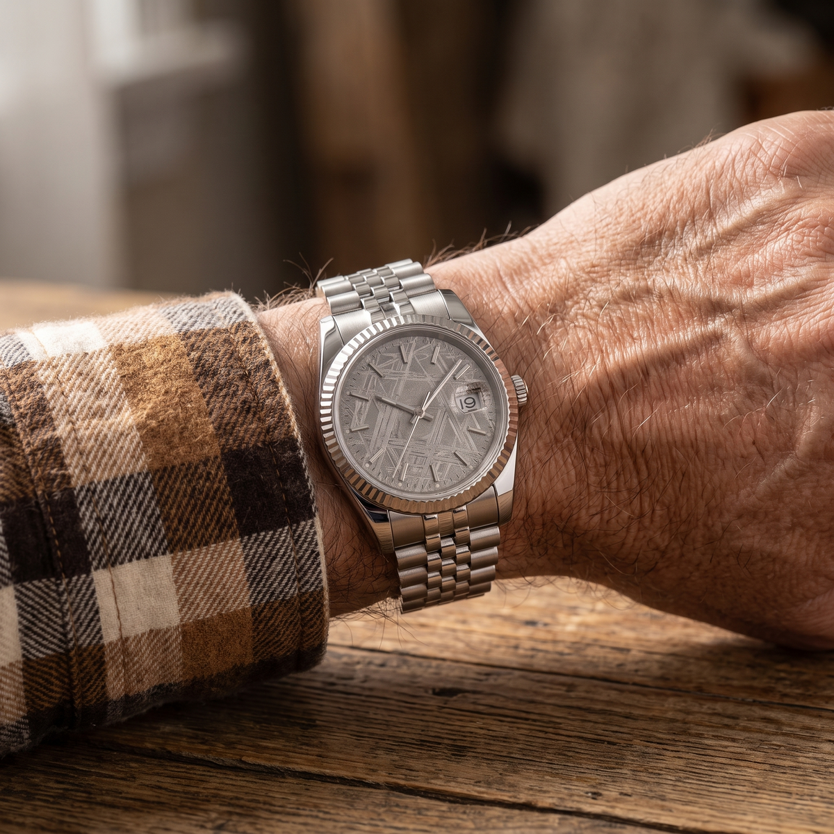 The meteorite watch worn on the wrist of an older man in a checked shirt