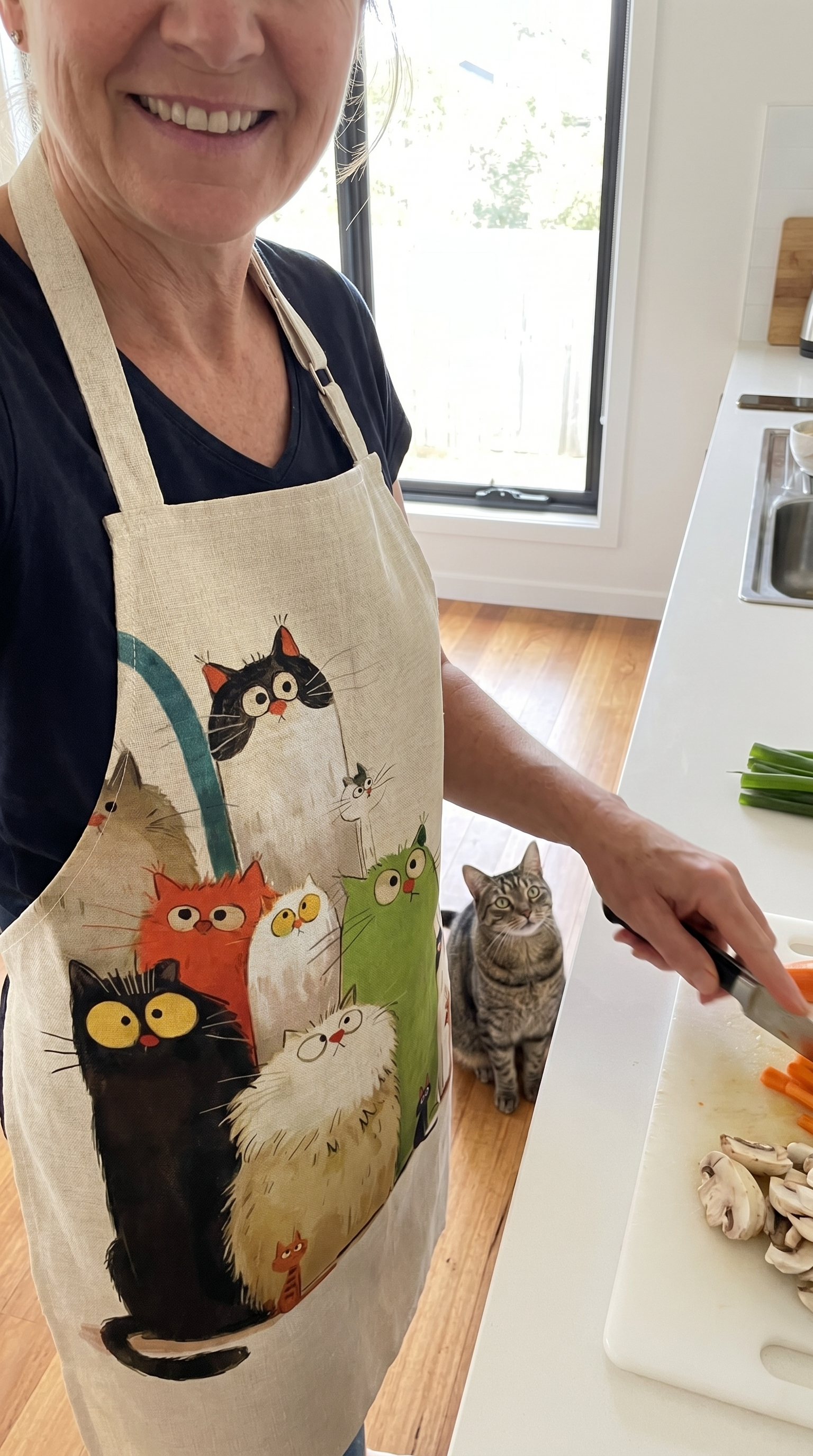 Customer cooking in the cat apron, her cat watching from the counter